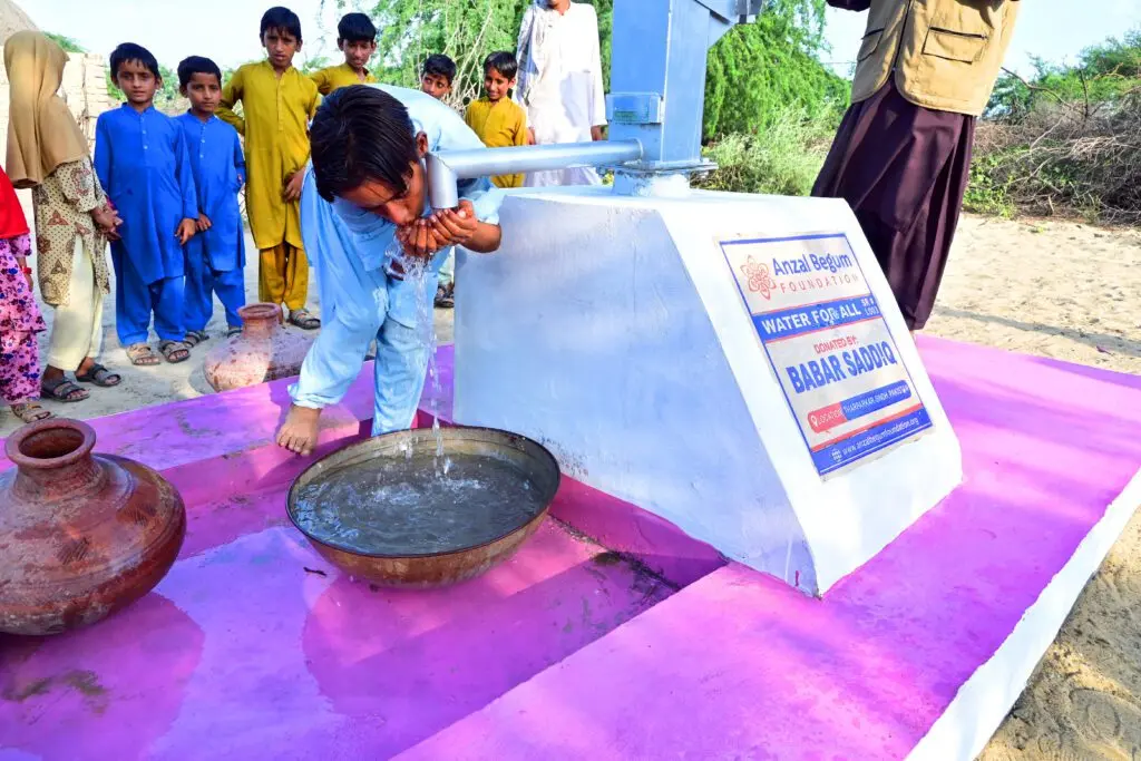 Water for All project by Anzal Begum Foundation in Tharparkar, Sindh, Pakistan, with a child drinking from a pump, supported by Babar Sadiq