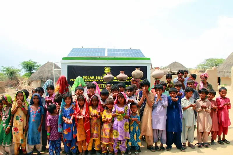 ISWA solar submersible clean water pump project in Pakistan, with children and community members celebrating access to clean water, supported by Sindh Development Organization
