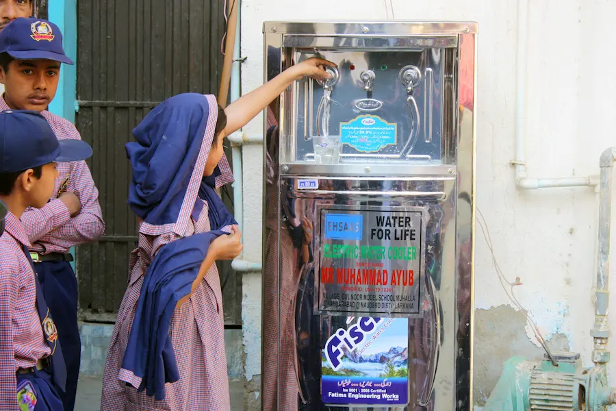 “School children filling water from stainless steel electric water cooler in Pakistan by SDO