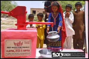 A girl drinking from a small water pump by SDO